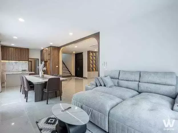 Spacious open-plan living and dining area in 4-bed condo for rent at The City Ramintra-Wongwaen 2 featuring grey sofa and