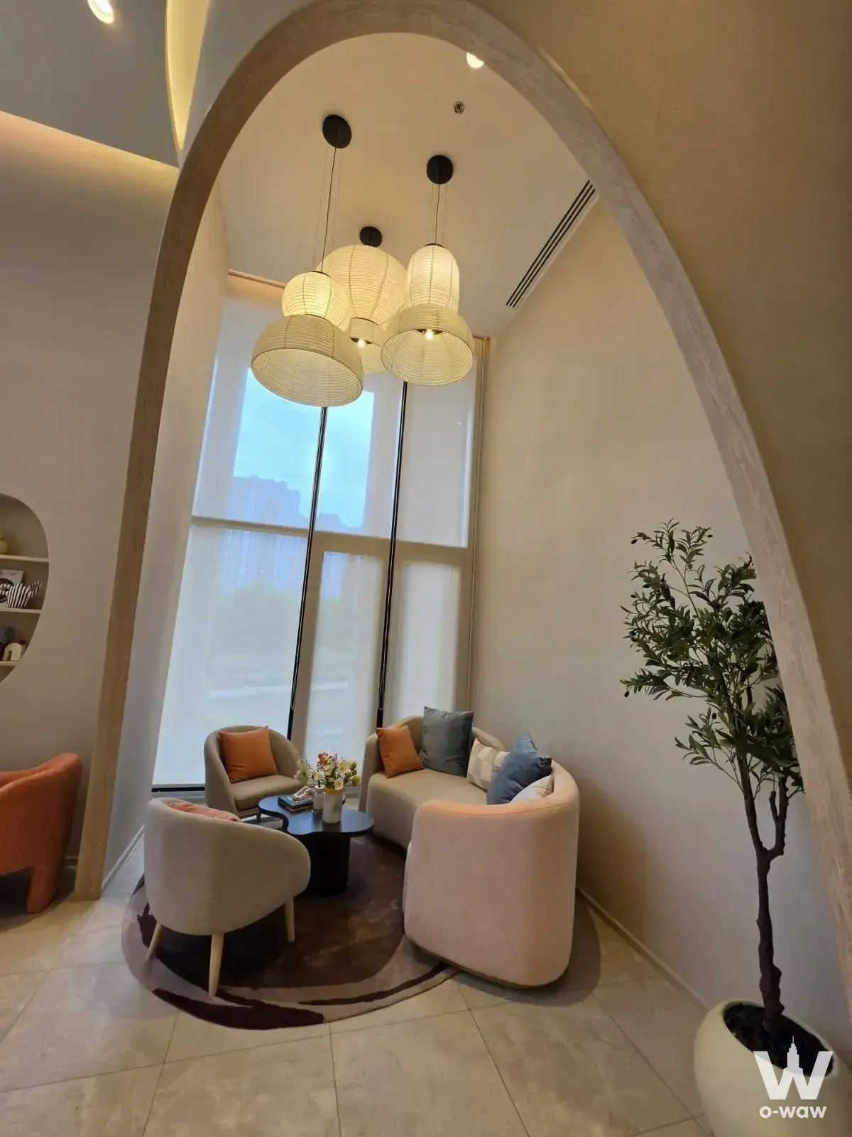 Modern living room with blush sofa and woven pendant lights in 3-bed condo for sale at COBE Ratchada-Rama 9