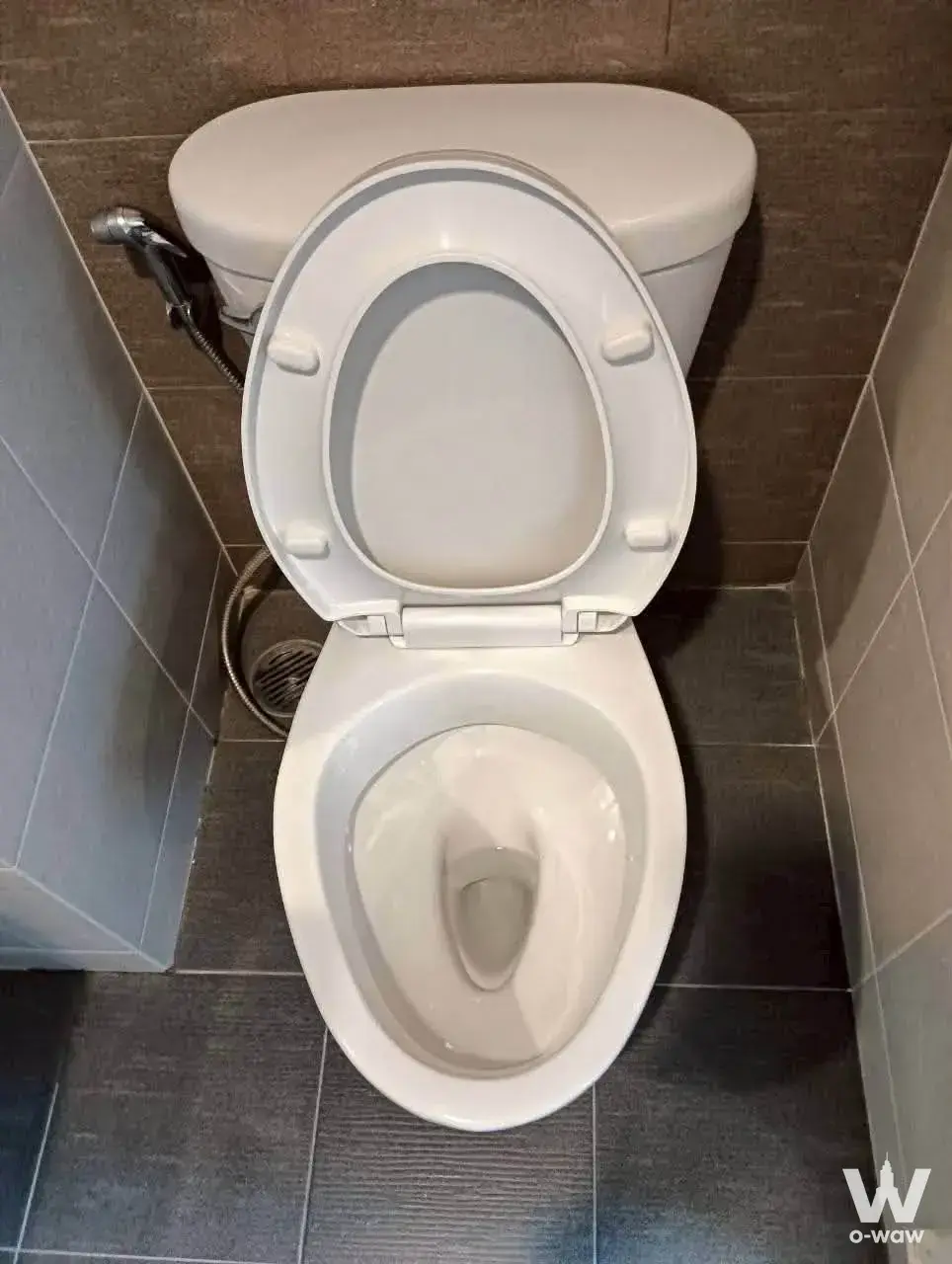 Compact bathroom with dark grey tiles and chrome bidet sprayer in Lumpini Park Phetkasem 98