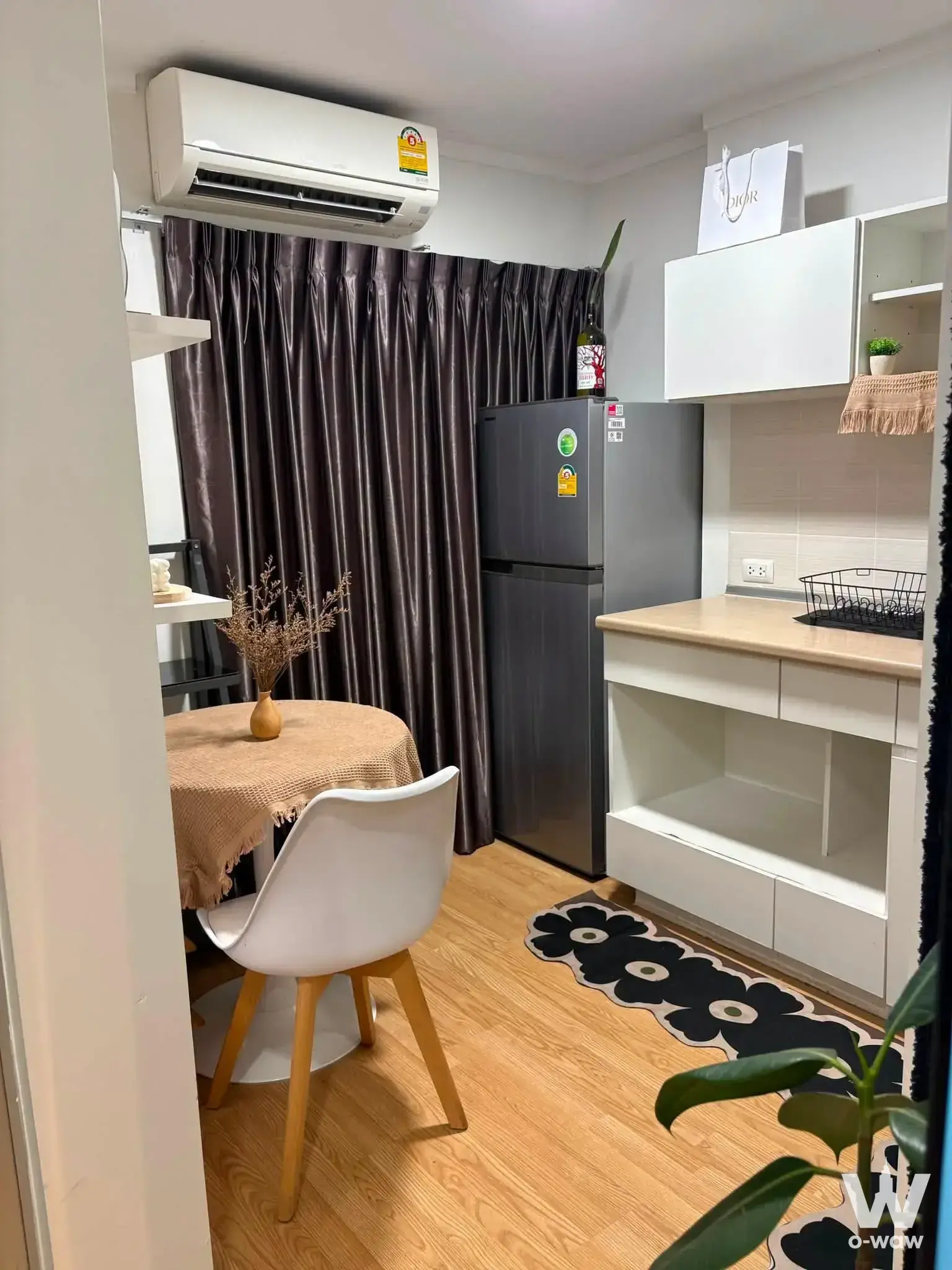 Compact kitchenette in a Lumpini Ville Sukhumvit 109 condo with light wood floors and a small round dining table