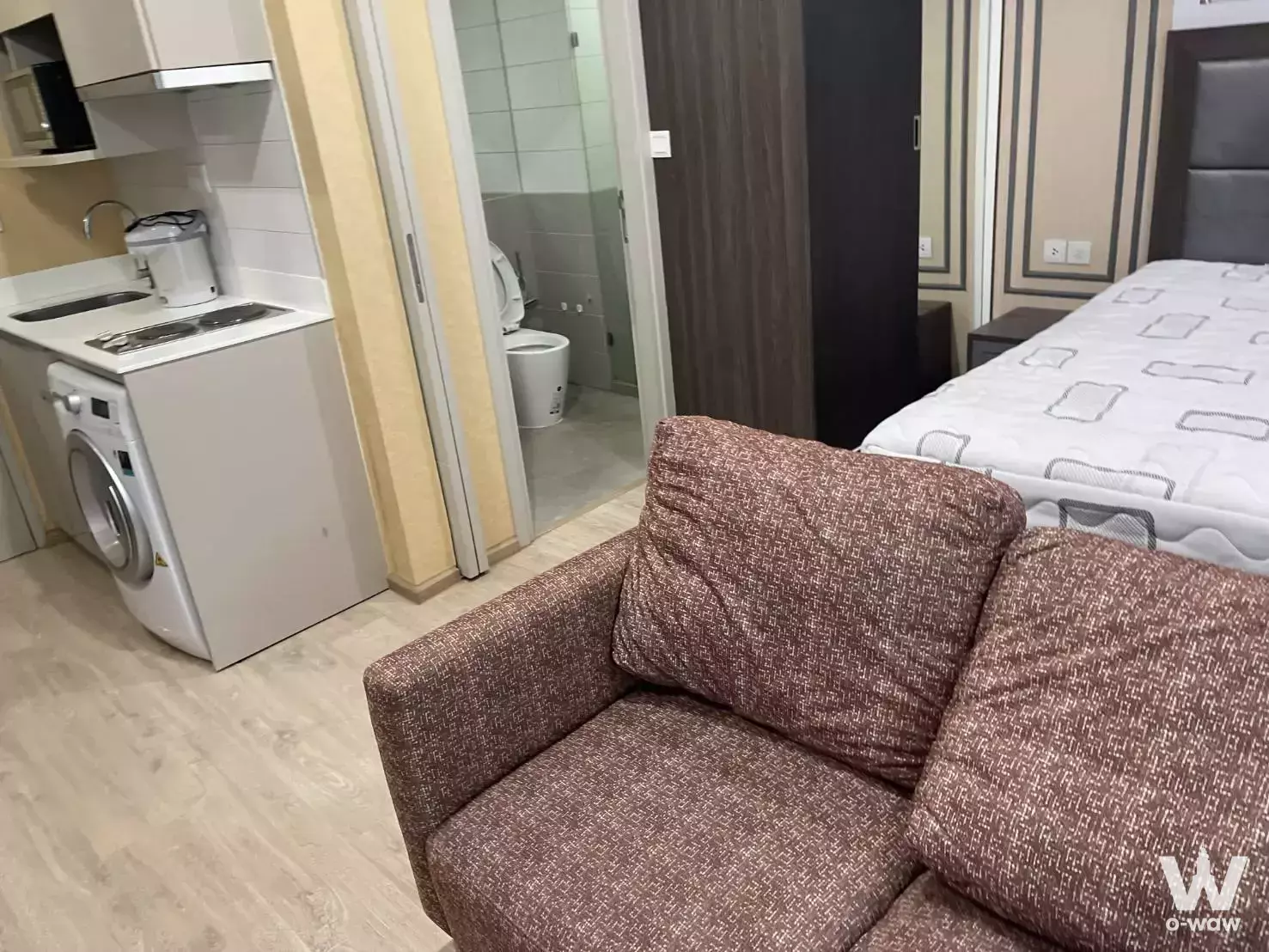 Modern 1-bed condo in Ideo Q Chula-Samyan with beige floors, grey bed, and compact kitchenette