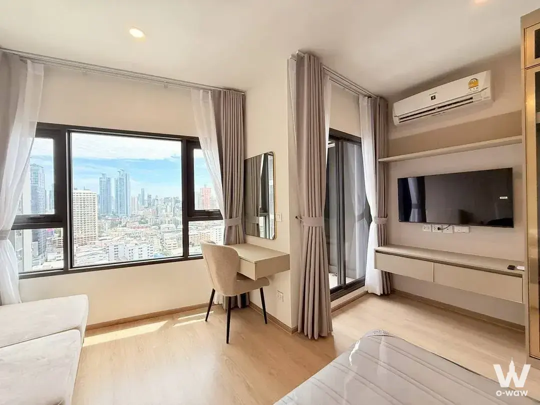 Bright 1-bed condo bedroom in Life Rama 4 with wood floors, large windows, and Bangkok skyline views
