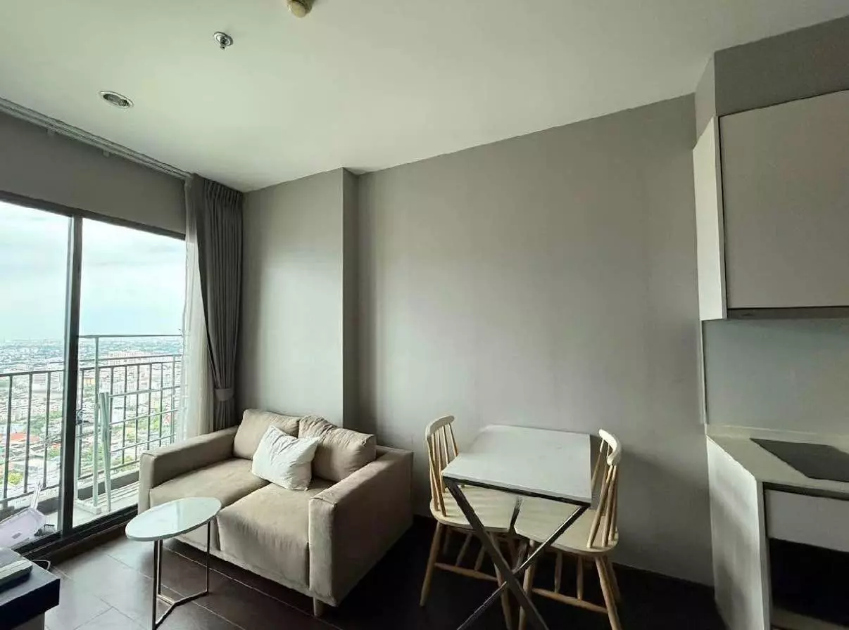 Modern 1-bed condo living area in C Ekkamai with city views, sofa, dining set, and kitchenette
