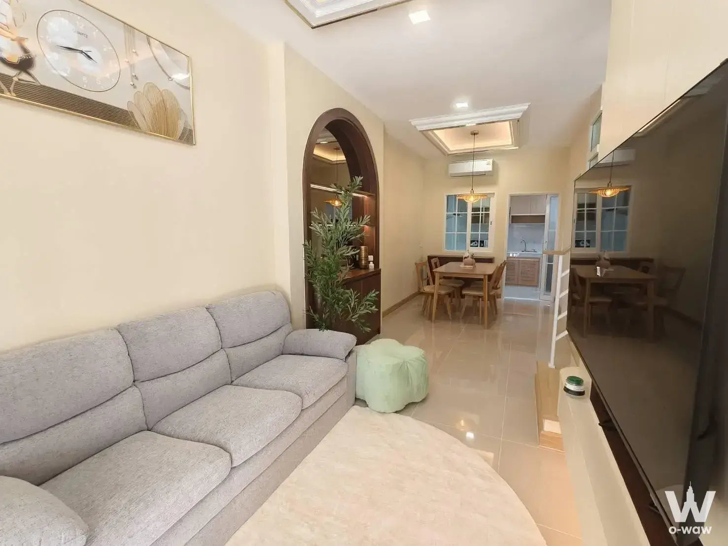 Furnished living and dining area in 2-bed townhouse for rent at Golden Town Bangna KM.5 featuring grey sofa and mint pouf