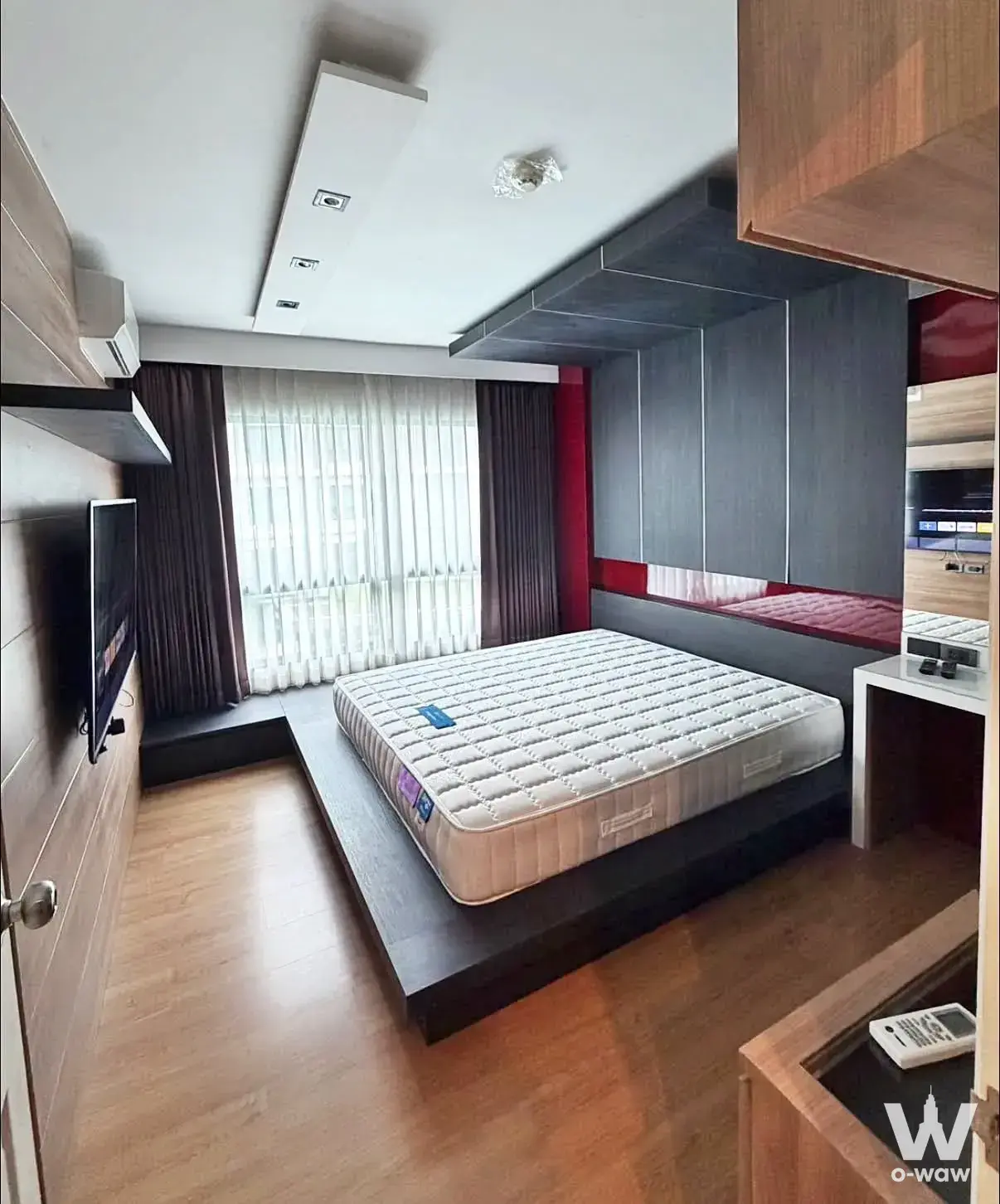 Bedroom in a Supalai City Resort rental featuring red accent wall and built-in grey wardrobe
