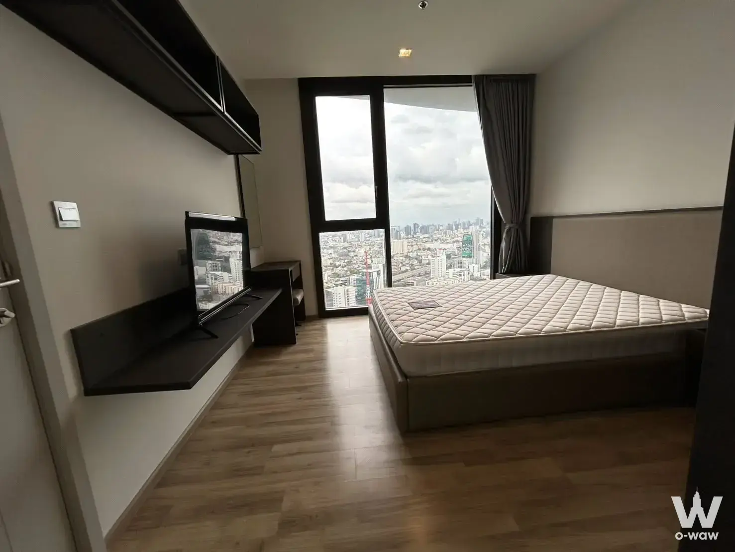 Modern bedroom with floor-to-ceiling windows and city views in this 1-bed condo for sale in THE LINE Chatuchak-Mo Chit