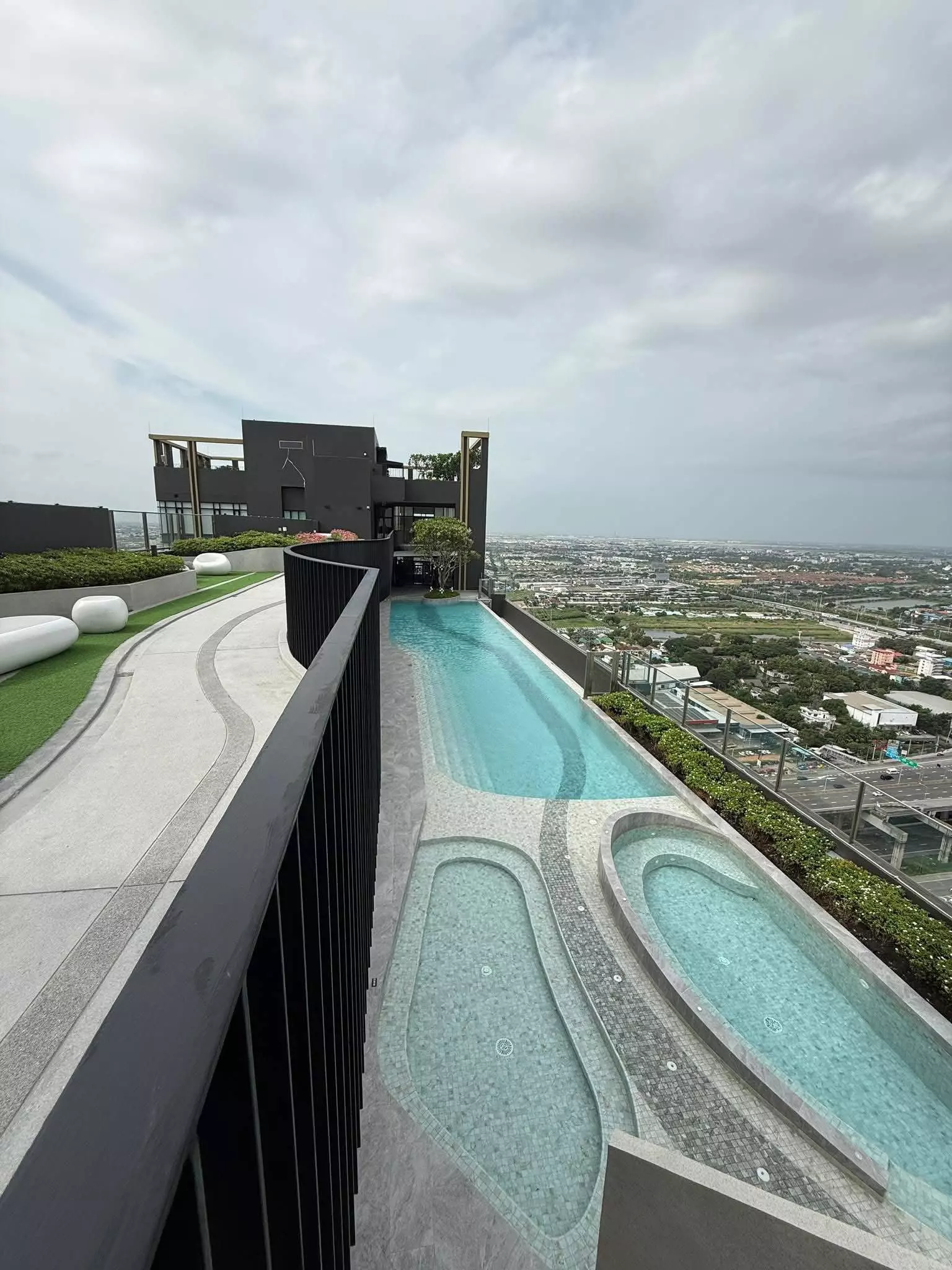 Infinity pool at Nue Mega Plus Bangna 1-bed condo rental with lap lane, jacuzzis, and city views