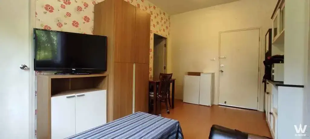 2-bed condo living area in Lumpini Condo Town Chonburi featuring floral wallpaper and media console
