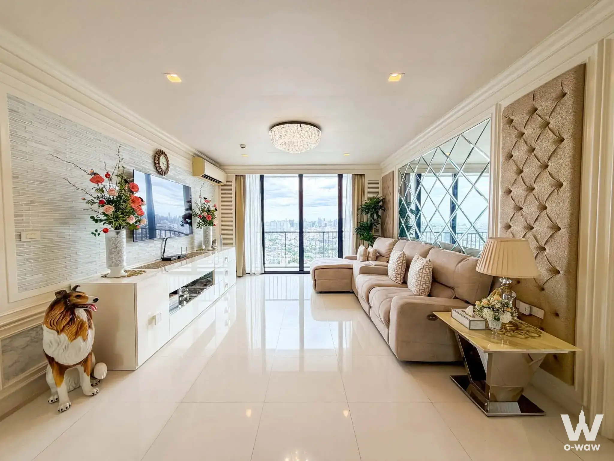 Luxury 2-bed condo living room in The Issara Ladprao with crystal chandelier and city skyline view