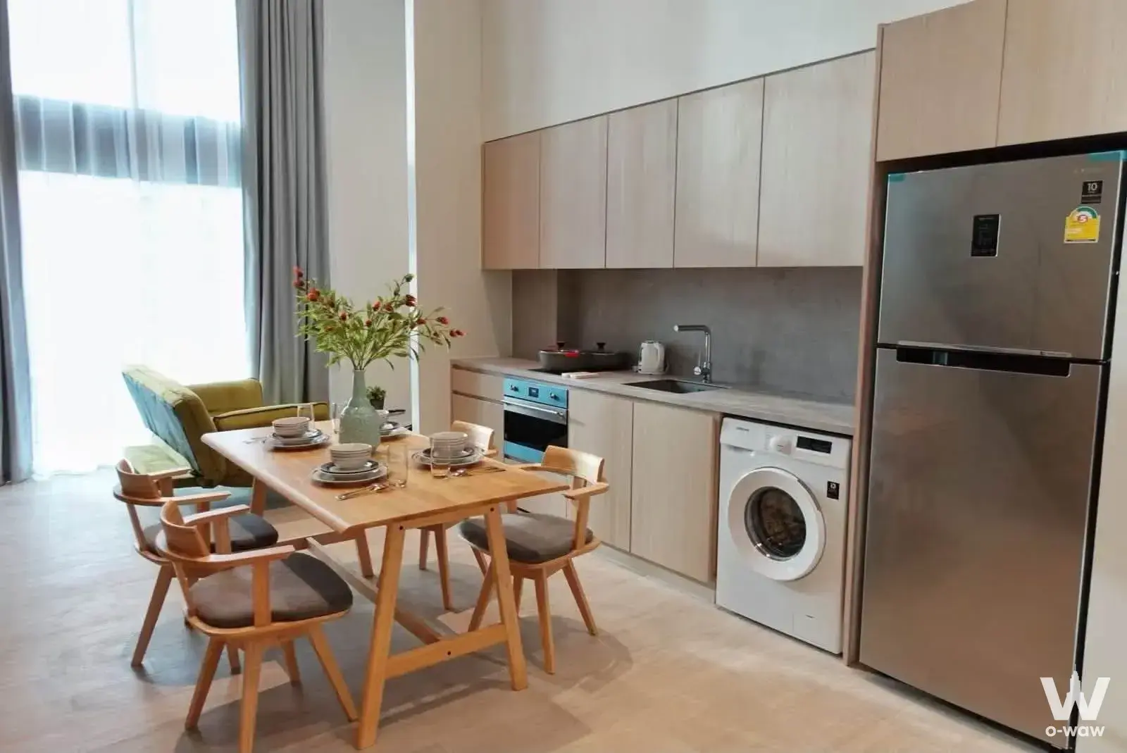The Lofts Silom 2-bed condo dining kitchen with oak table and olive armchair
