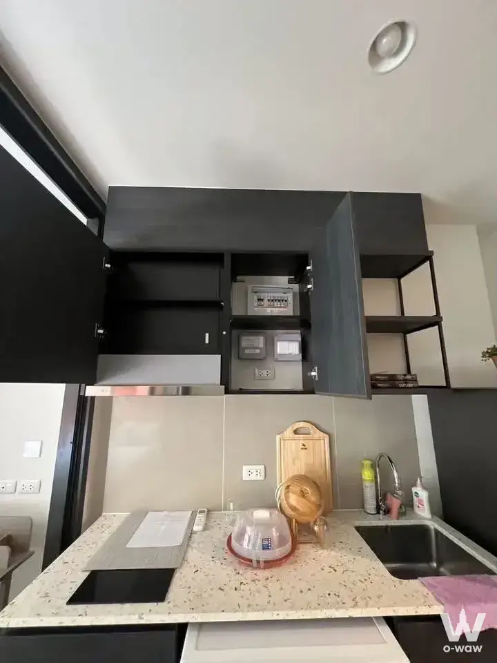 Modern kitchenette with charcoal cabinets and terrazzo counter in 1-bed condo for rent at XT Huai Khwang