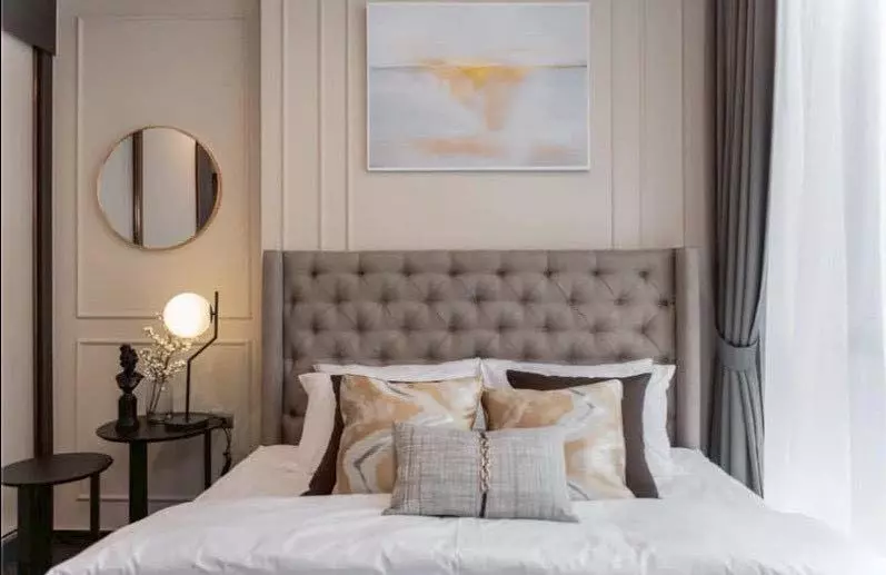 Modern bedroom in 1-bed LAVIQ Sukhumvit 57 condo with tufted headboard and gold accents