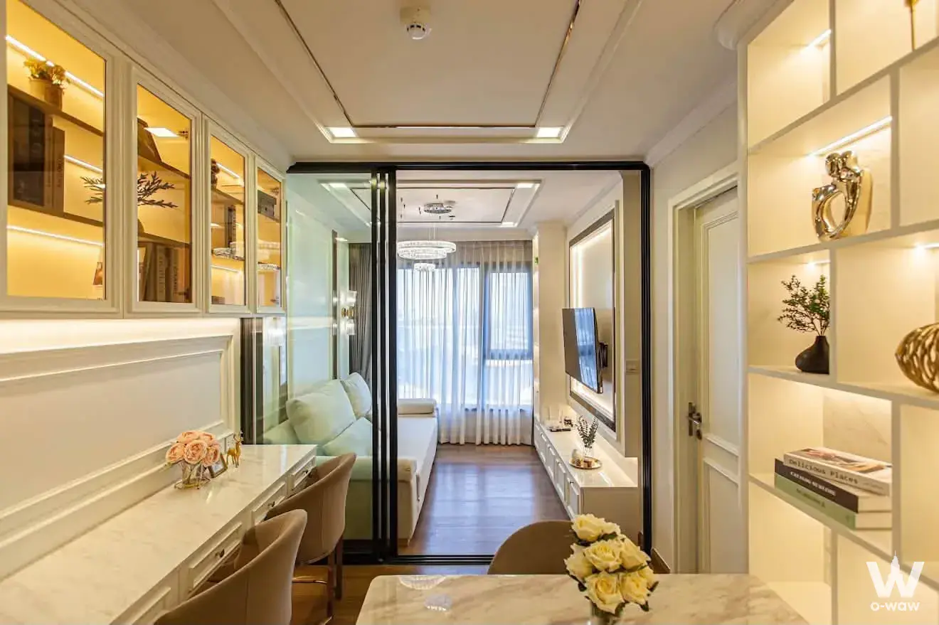 Study with marble desk opens to living room via glass doors in 1-bed condo for sale at Life Ladprao Valley