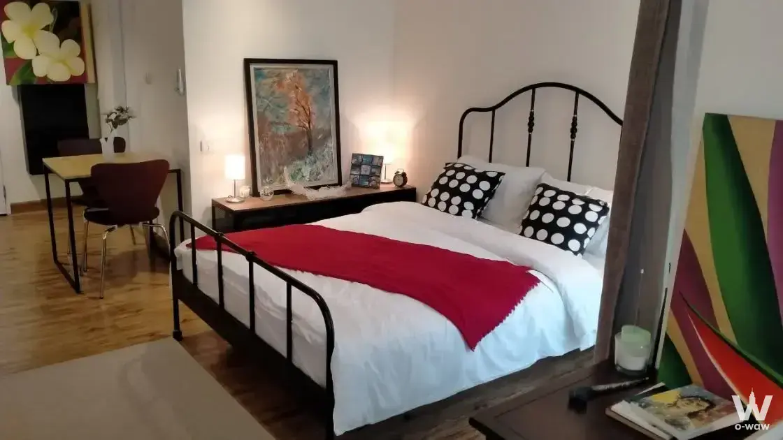 Queen-size bed with black metal frame and polka-dot pillows in a furnished bedroom at J.W. BOULEVARD Srivara