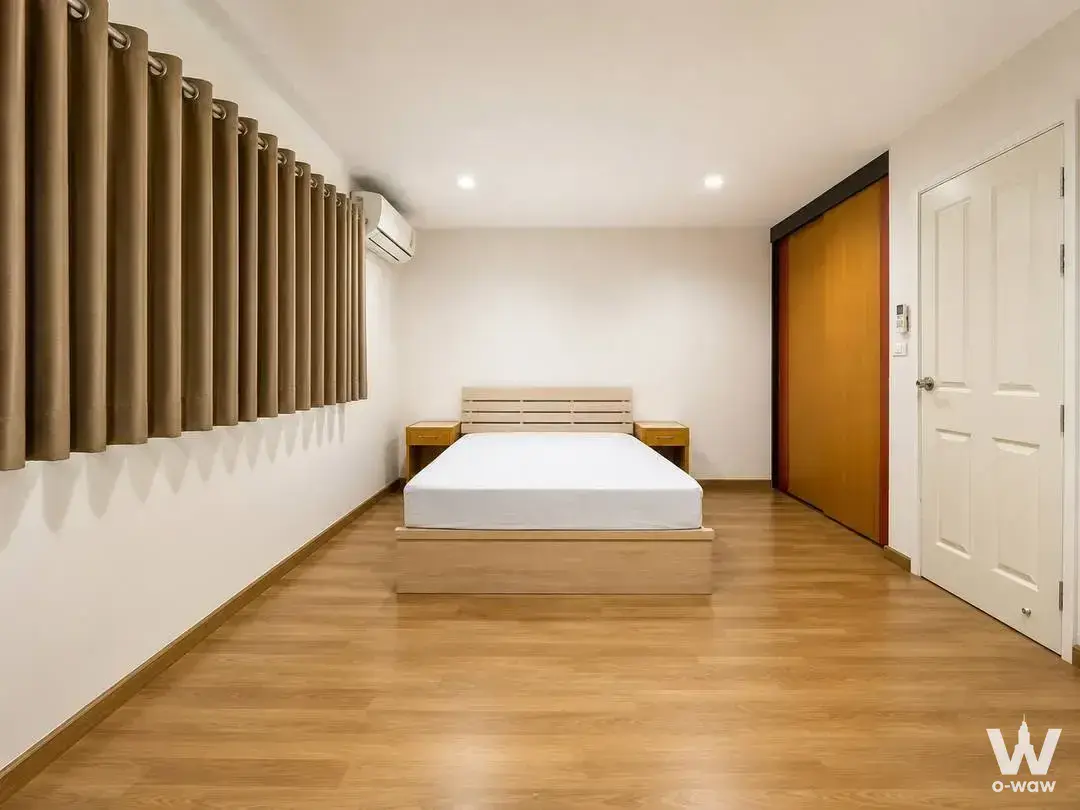 Minimalist bedroom with wood flooring and wardrobe in 3-bed townhouse for rent at Villette City Pattanakarn