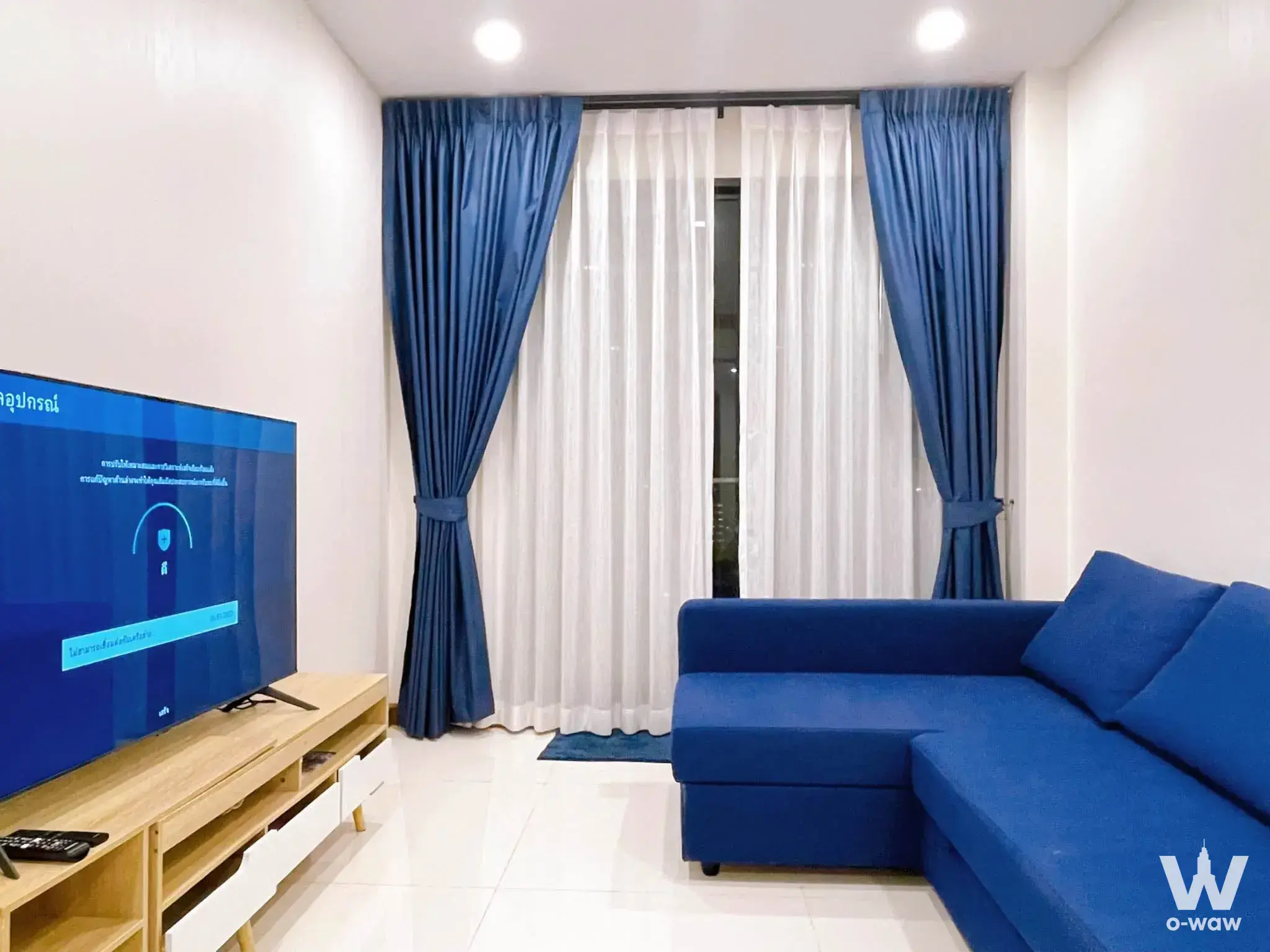 Modern 1-bed condo living room in Supalai Premier Charoen Nakhon featuring blue sectional sofa