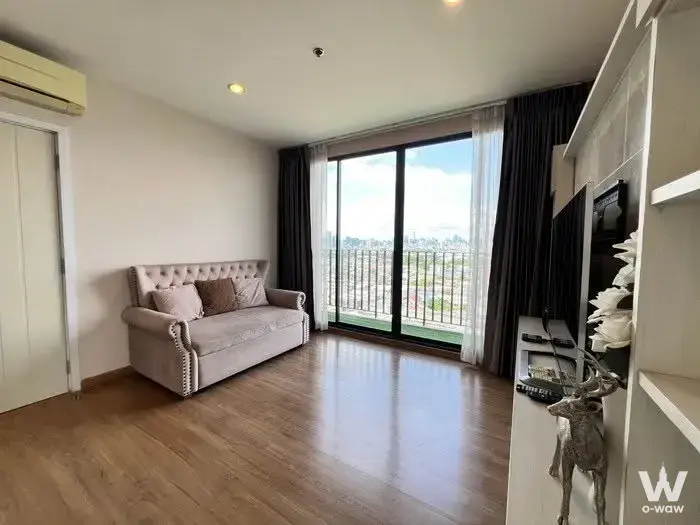 Modern living room in 2-bed The Tree Interchange rental with cream sofa and balcony city views
