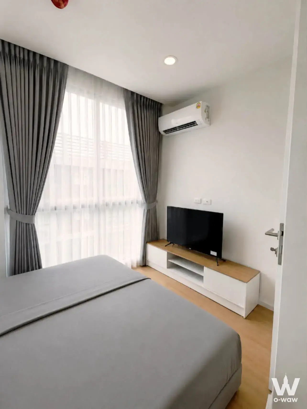 Modern 1-bed condo bedroom in Cerocco Bangna 36 with grey linens and minimalist design
