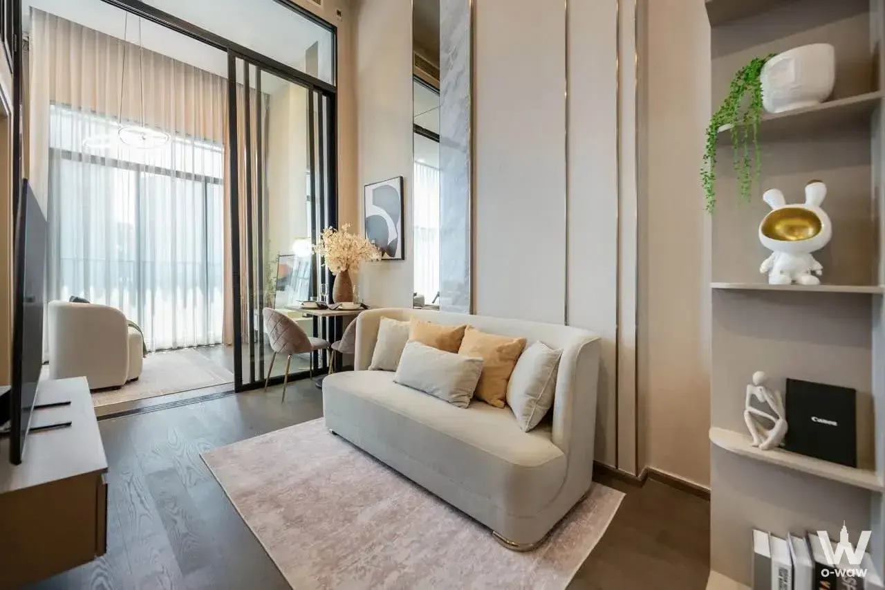 Cream sofa living room with gold accents and marble column in Park Origin Ratchathewi 2-bed condo