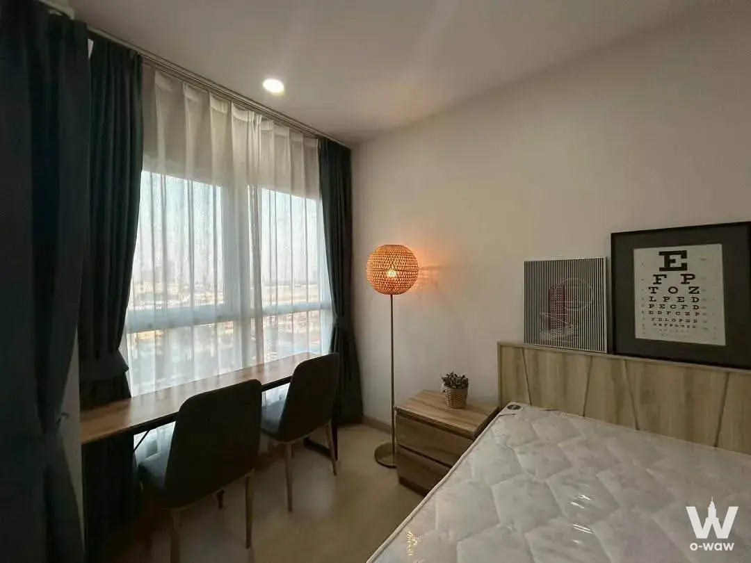 Modern 1-bed condo bedroom in Supalai Veranda Ramkhamhaeng with wood floors, desk by window and rattan lamp