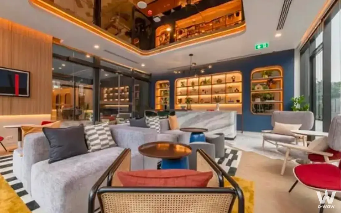 THE BASE Phetchaburi-Thonglor lobby lounge with navy accent wall, copper coffee tables, and modern luxury furnishings