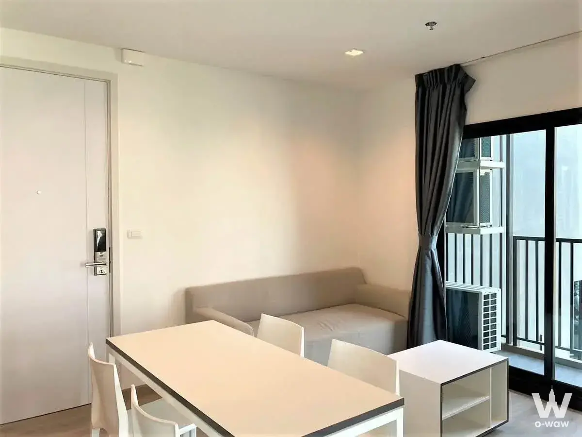 Modern living room in 2-bed condo at THE BASE Phetkasem with white dining set and balcony view