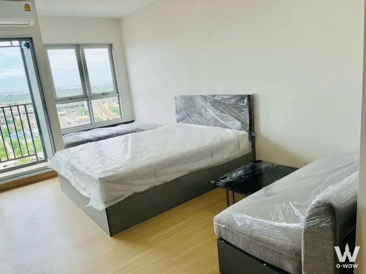 Queen bed and sofa in a move-in ready 1-bed condo for rent at Supalai Veranda Sukhumvit 117