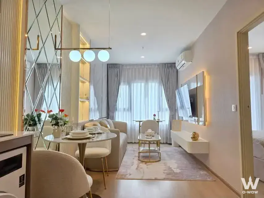 Open-plan living and dining area in a 1-bed condo at Life Rama 4 Asoke featuring gold accents and marble table