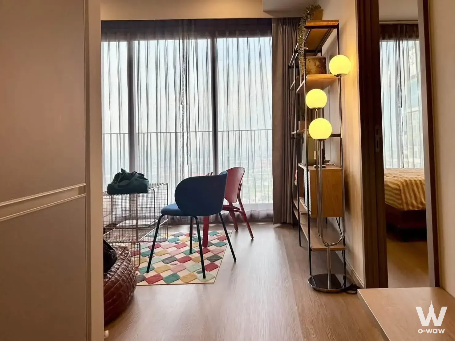 Eclectic 2-bed condo living room in Whizdom The Forestias with patchwork rug and floor-to-ceiling windows