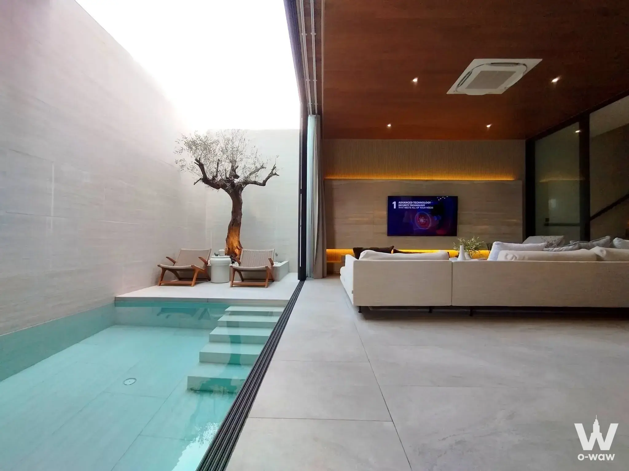 Open-air lounge in a Motif Sukhumvit Bangna villa featuring a plunge pool, cream sectional, and wood-paneled ceiling