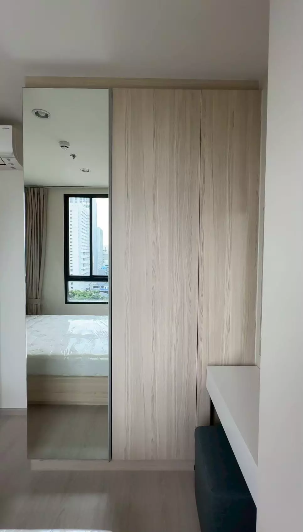 Modern bedroom in 2-bed condo for rent at NUE Noble Ratchada Lat Phrao with mirrored wardrobe and city view