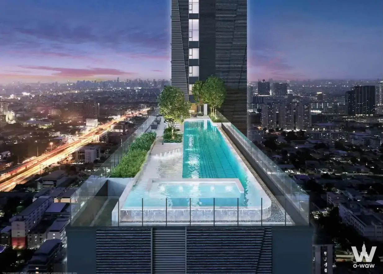 Infinity pool and jacuzzi on a rooftop deck with city skyline views at Modiz Voyage Srinakarin