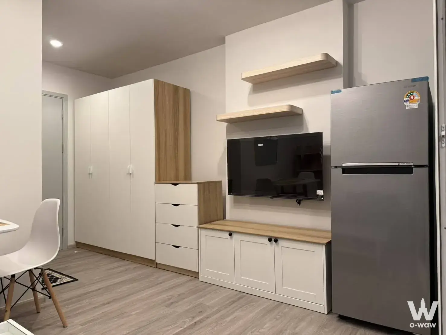 Furnished living room in Regent Home Bangna condo with built-in oak storage and wall-mounted TV