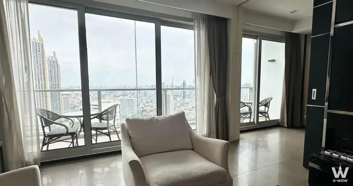 Modern living room with floor-to-ceiling windows and city views in 2-bed condo for rent at The River Condominium Bangkok