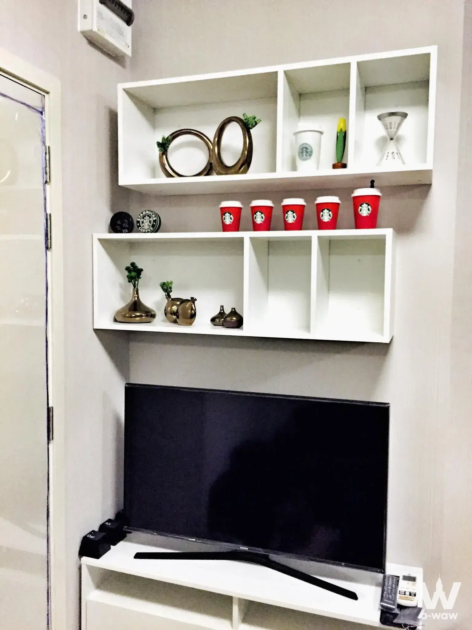 Modern living room in 1-bed for sale at Fuse Sense Bangkae with floating TV console and asymmetrical shelving