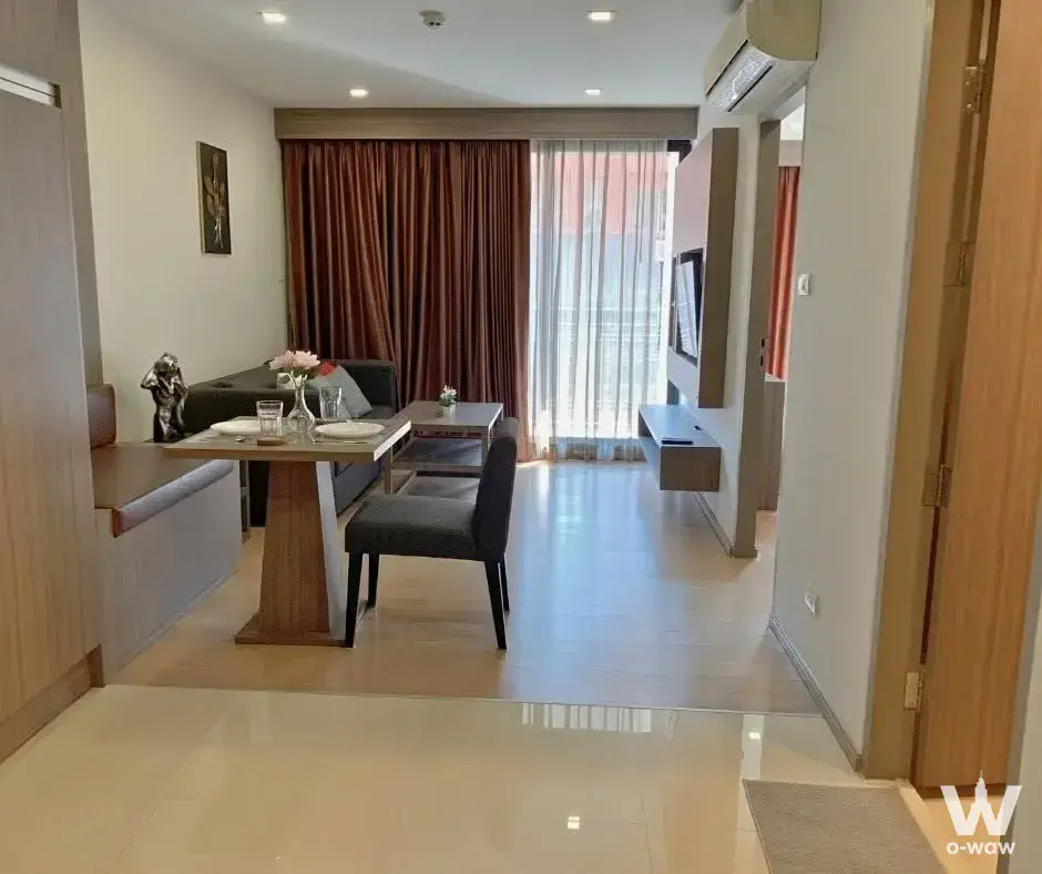 Open-plan living area with a dining set and floor-to-ceiling windows in this 1-bed condo for rent at art @ Thonglor