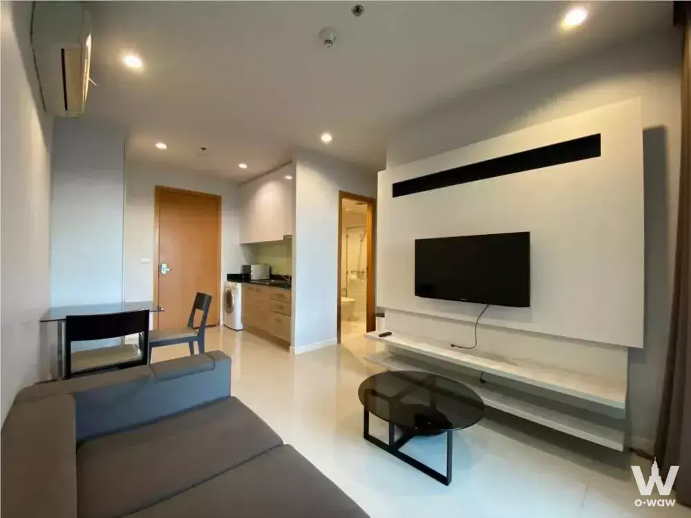 Modern 1-bed condo for rent in Circle Condominium featuring glossy white floors, grey sofa, and open kitchenette