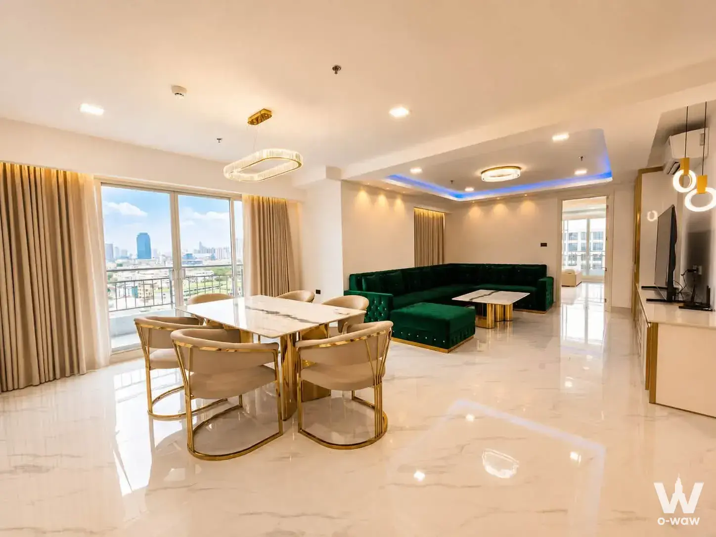Open-plan living and dining room in a 2-bed condo for sale at Supalai Prima Riva with emerald green sofa