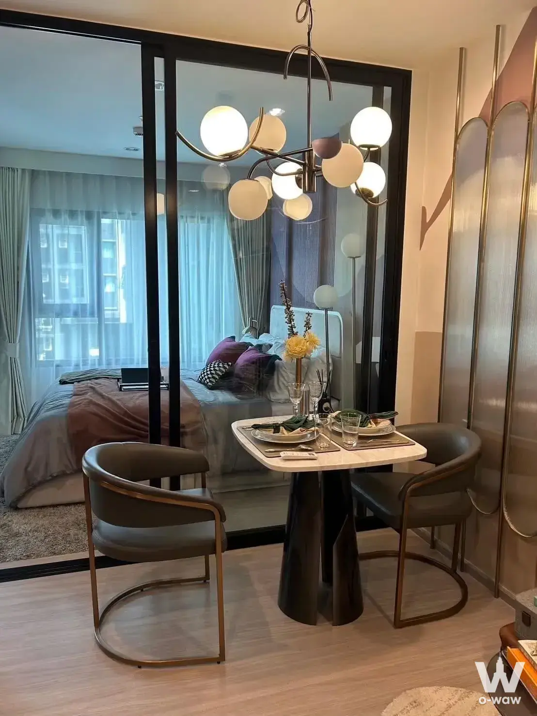 Modern dining nook with marble table and glass doors to bedroom in Aspire Erawan Prime 1-bed condo for rent