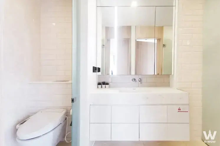 Modern all-white bathroom with floating vanity and subway tiles in 2-bed condo for rent at Siamese Exclusive Sukhumvit 42