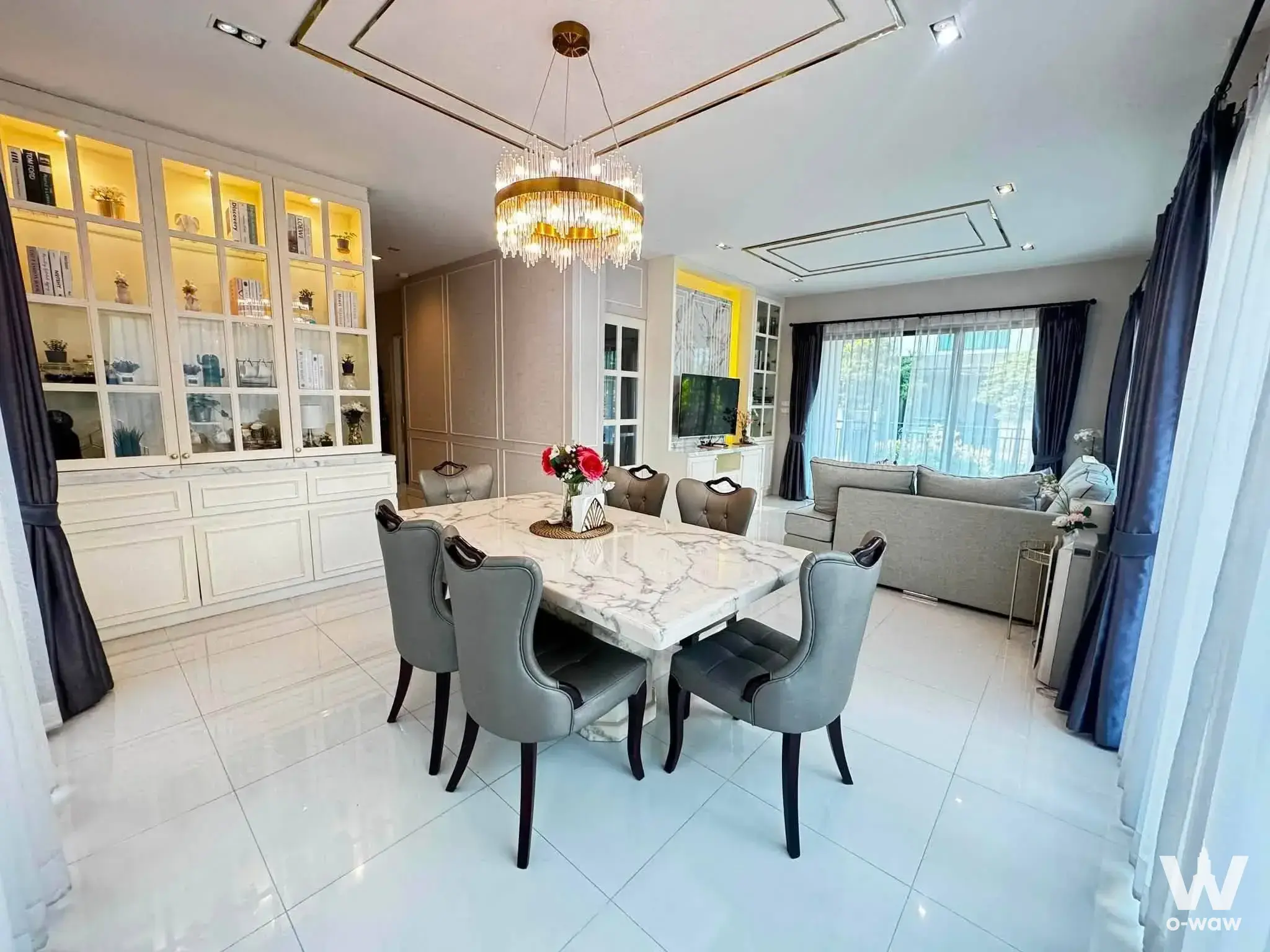 Marble dining table under gold chandelier in a 4-bed house for rent at Bangkok Boulevard Rama 9