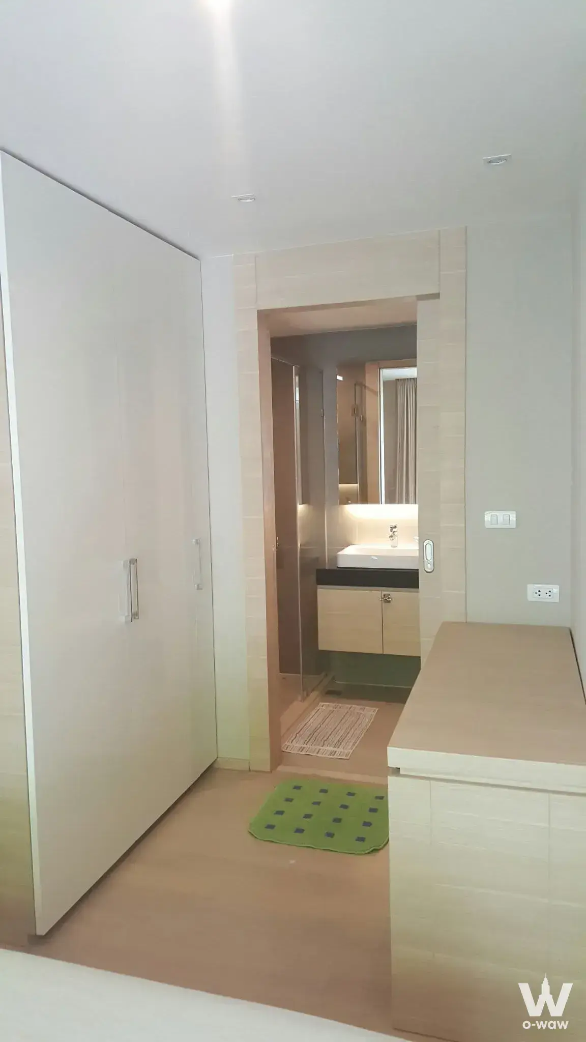 Modern bedroom in Klass Silom Condo with floor-to-ceiling wardrobe and en-suite bathroom featuring light wood finishes