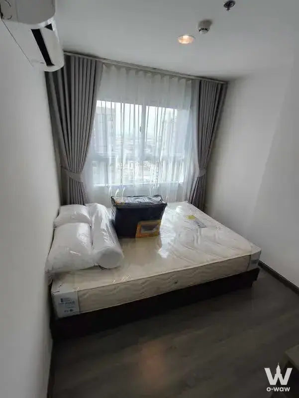 Queen bed in 1-bed condo for rent at The Trust Residence Pinklao with grey laminate floors and city view