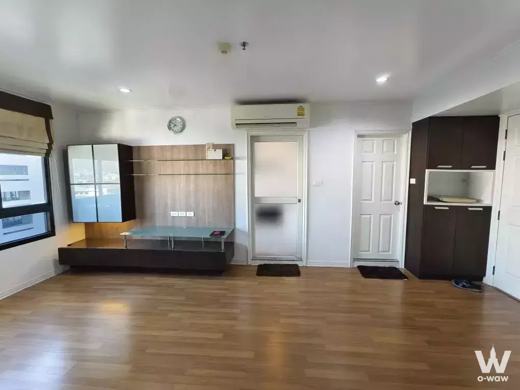 Unfurnished living room in 2-bed condo for sale Lumpini Place Phahon-Saphan Khwai with wood floors and built-in media unit