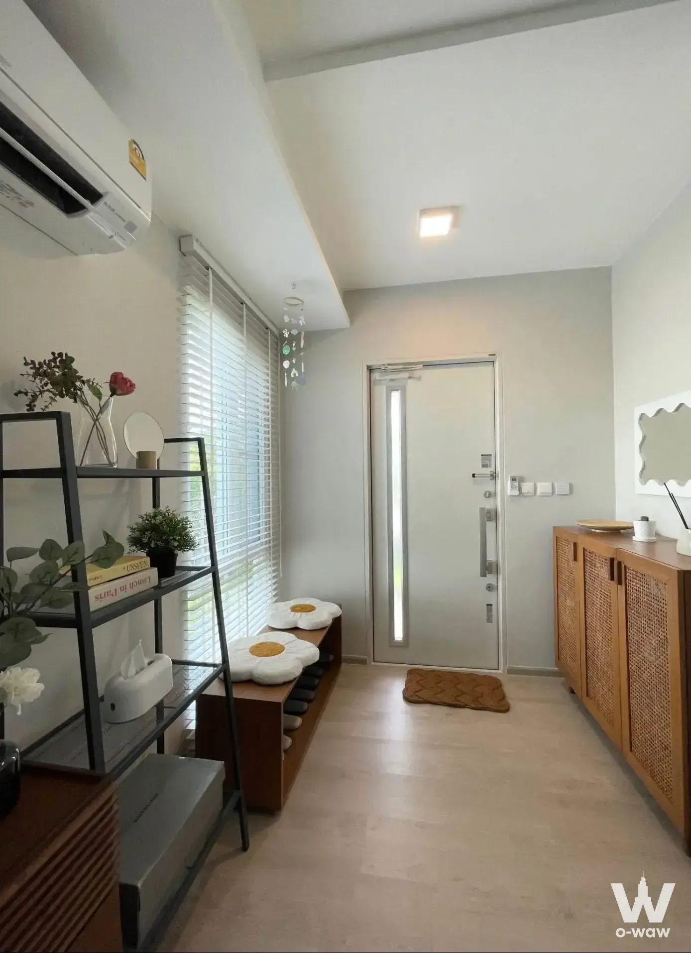 Bright entryway of 2-bed house for sale in Anya Bangna-Ramkamhaeng 2 with wooden bench and rattan cabinet