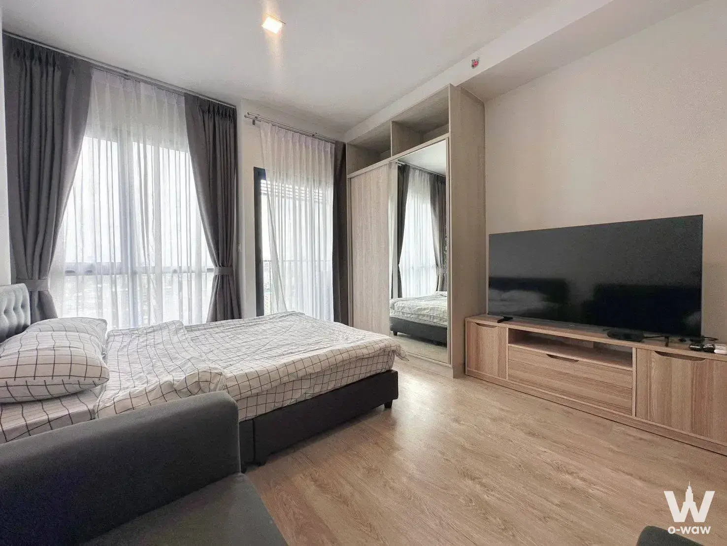 The Tree Pattanakarn-Ekkamai studio featuring floor-to-ceiling windows and a tufted headboard
