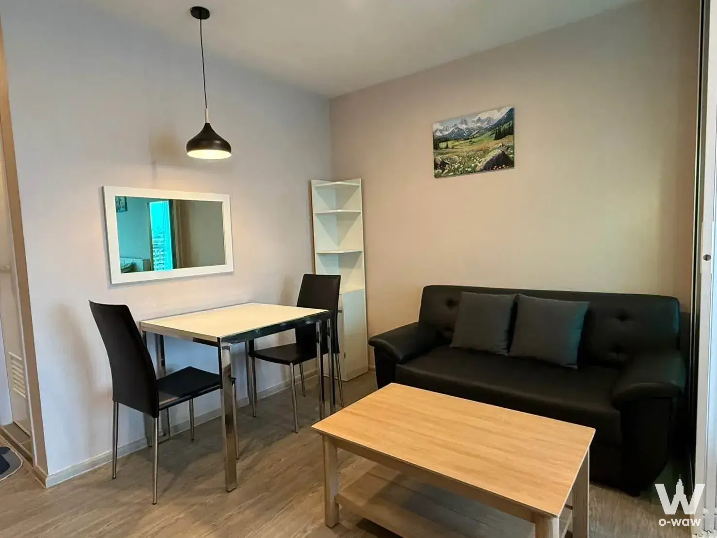 Black leather sofa and dining set in a furnished Regent Home Bangna condo living area