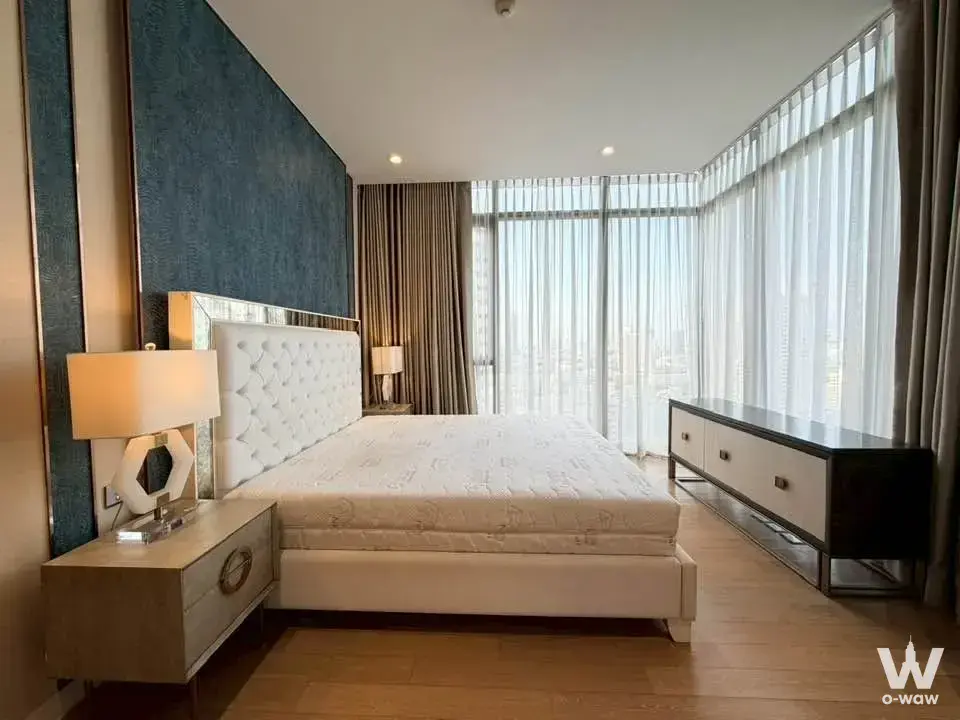 Modern 2-bed condo bedroom in VITTORIO Sukhumvit 39 with teal headboard and city views