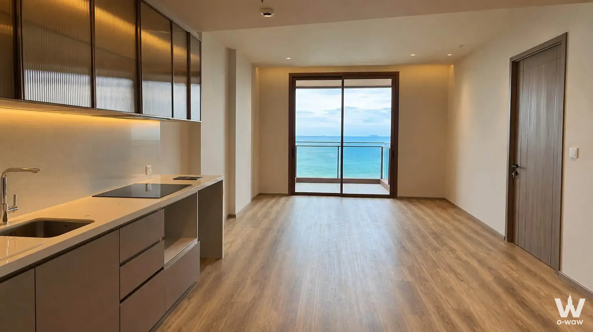 Open-plan kitchen with dark wood cabinets and direct ocean view in 2-bed condo for sale at AROM JOMTIEN