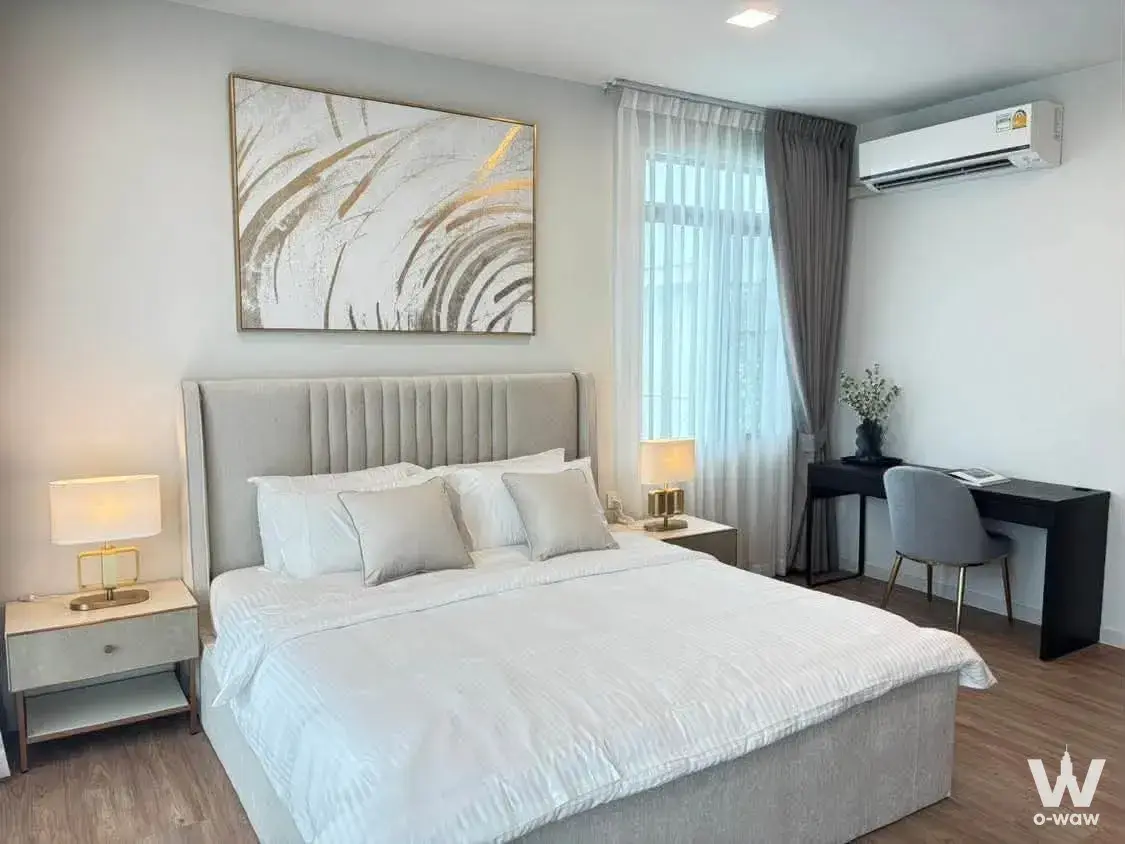 Master bedroom in a 4-bed house for rent at Mantana Bangna Km.15 featuring a tufted headboard gold accents and abstract art